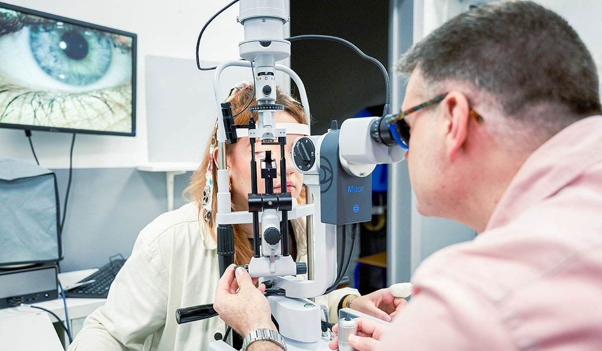 Formateur guidant une étudiante pendant un examen au biomicroscope à l’Institut Supérieur d’Optique