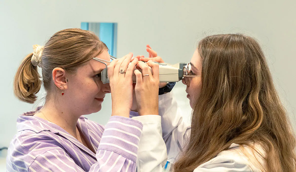 Deux étudiantes observant un montage optique pendant un cours pratique à l’Institut Supérieur d’Optique